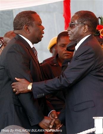 Zimbabwean President Robert Mugabe (R) greets Zimbabwean Prime Minister Morgan Tsvangirai